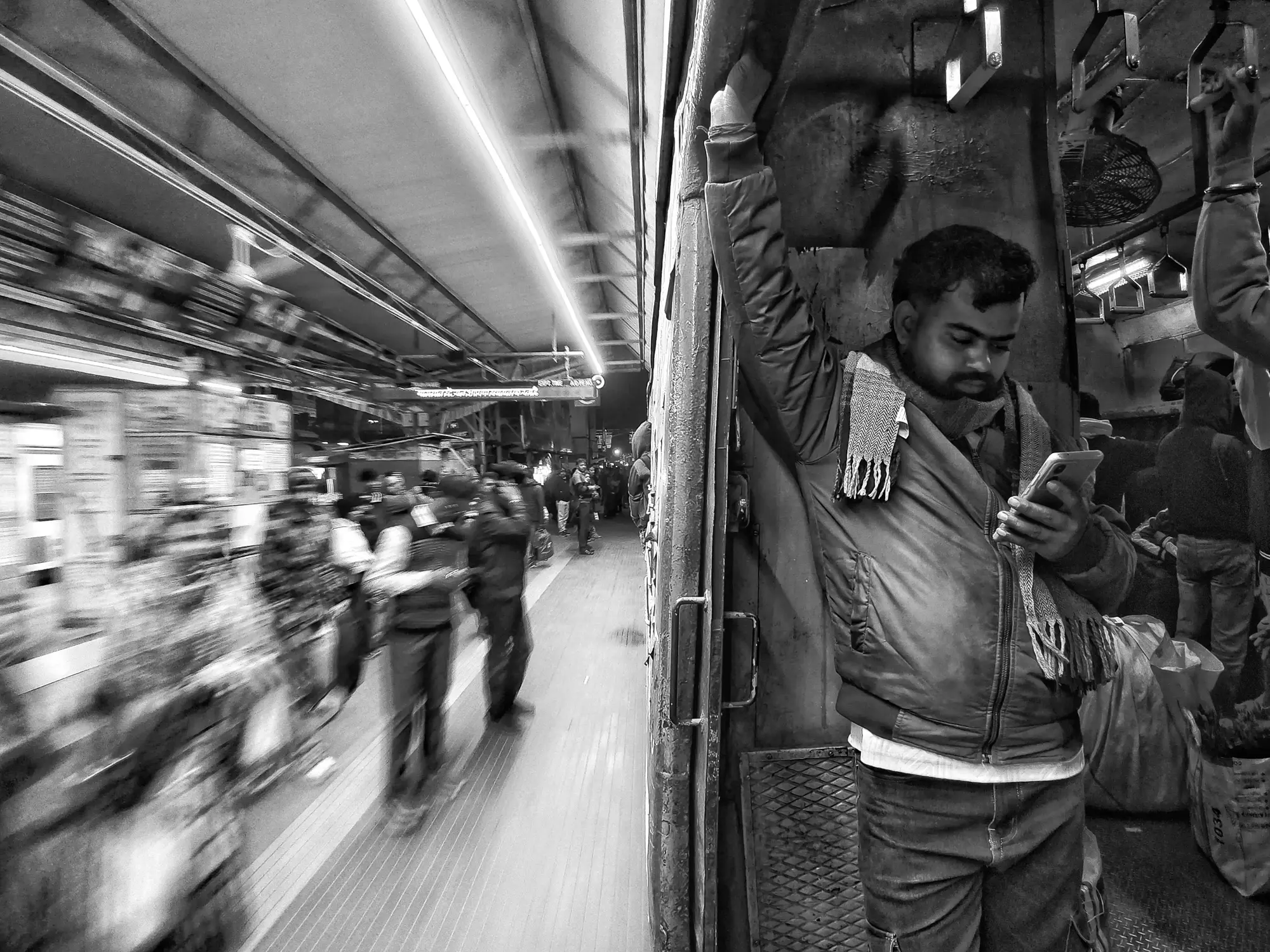 Indian man in train watching phone