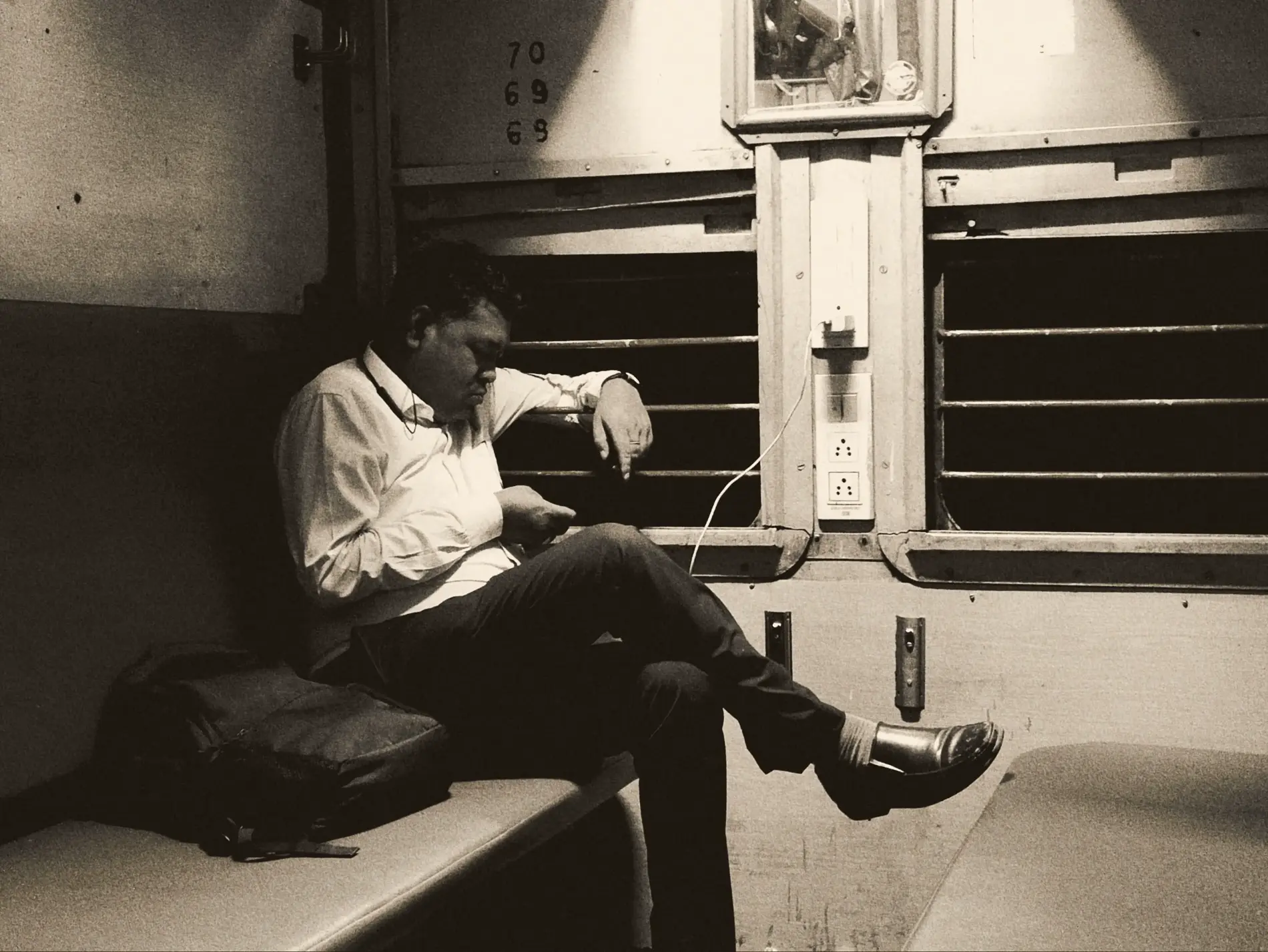 Indian man in train coach using phone
